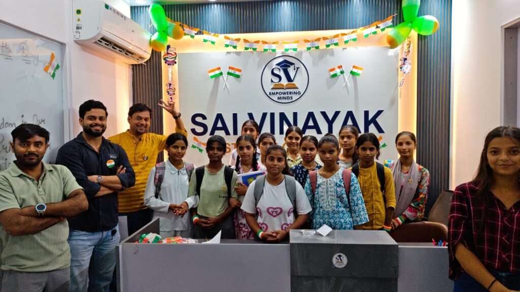 Students and teachers stand together for a group photo with the Sai Vinayak Institute banner
